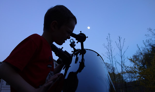 A boy and his Dob viewing the Moon.